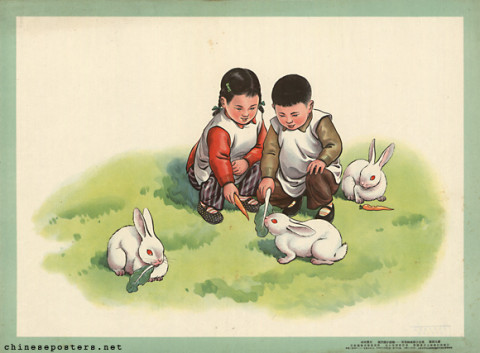 Older brother and younger sister feed small white rabbits